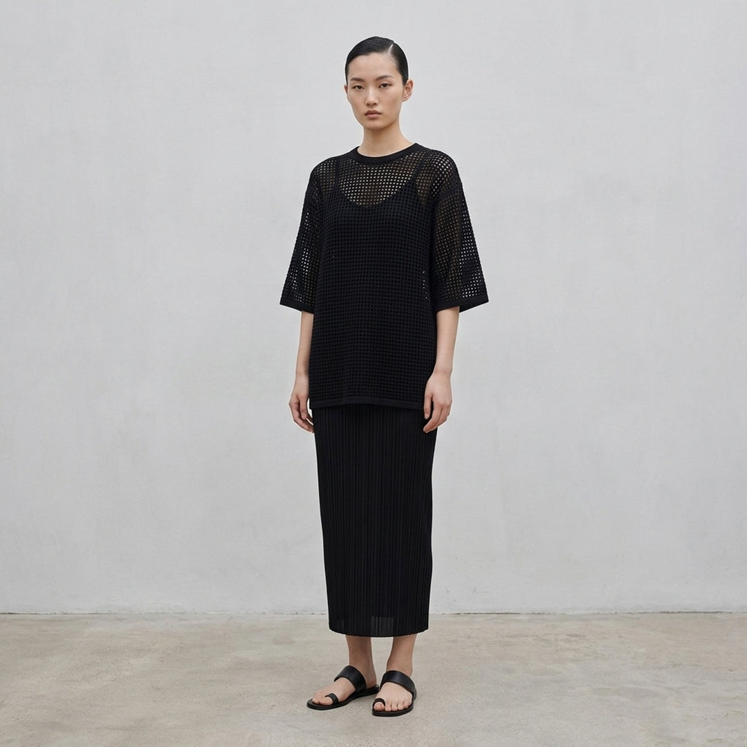 Pleats Please Issey Miyake Dot Knit — black open-work oversized half-sleeve crew neck top, shown flat from the front - lifestyle