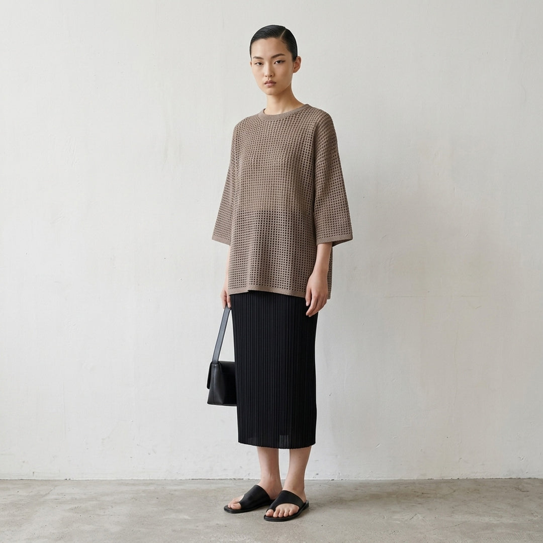Pleats Please Issey Miyake Dot Knit — black open-work oversized half-sleeve crew neck top, shown flat from the front - lifestyle