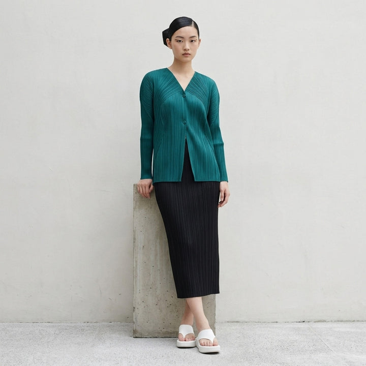 Back view of a sand-toned pleated long-sleeve cardigan from Pleats Please Issey Miyake with pleats fanning across the back - lifestyle