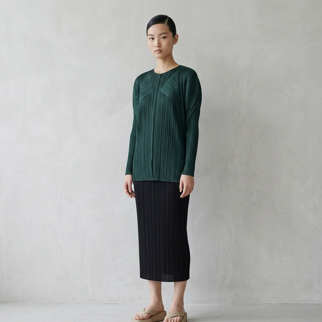 Back view of a sand-toned pleated long-sleeve cardigan from Pleats Please Issey Miyake with pleats fanning across the back - lifestyle