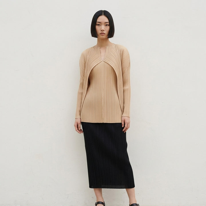 Back view of a sand-toned pleated long-sleeve cardigan from Pleats Please Issey Miyake with pleats fanning across the back - lifestyle