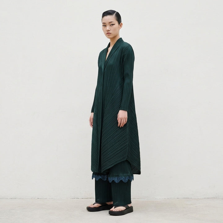 Pleats Please Issey Miyake Monthly Colors October long pleated coat in deep forest green, shown from the front with an open, flowing silhouette - lifestyle