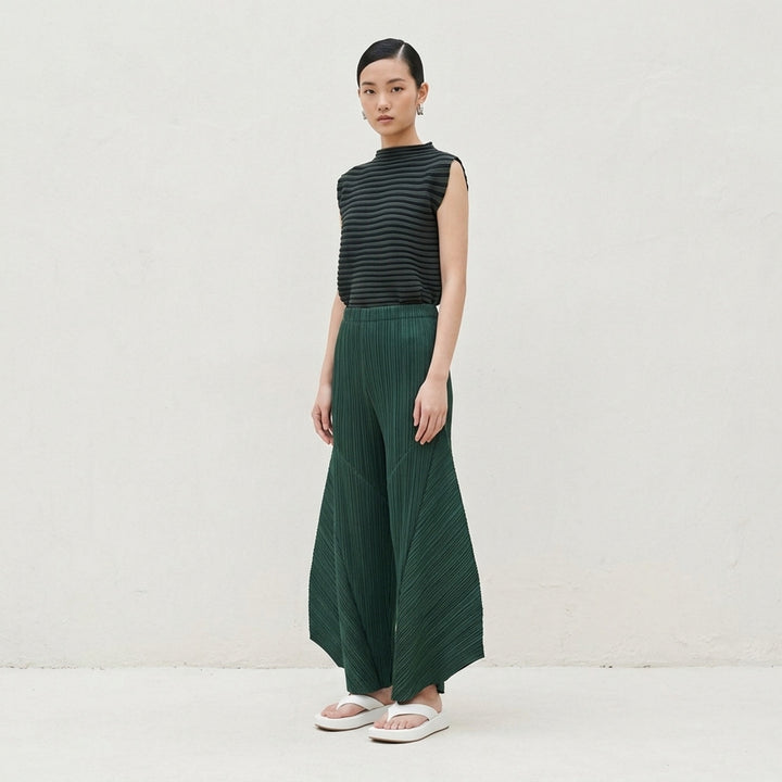 Pleats Please Issey Miyake Monthly Colors October pleated flared pants in deep green with sculpted side panels and elasticated waist - lifestyle