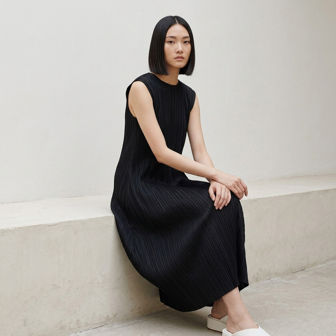 Pleats Please Issey Miyake Monthly Colors September sleeveless black micro-pleated dress with draped balloon hem, front view on white background - lifestyle