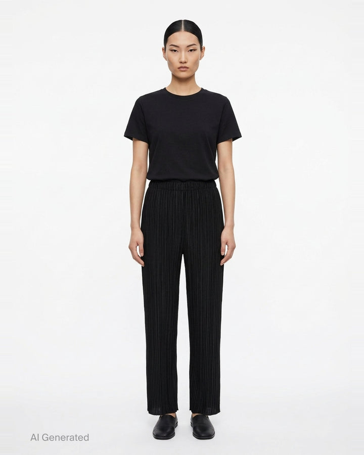 Pleats Please Issey Miyake Monthly Colors September wide-leg pants in black, featuring fine vertical micro-pleating and an elasticated waistband, displayed flat against a white background - front