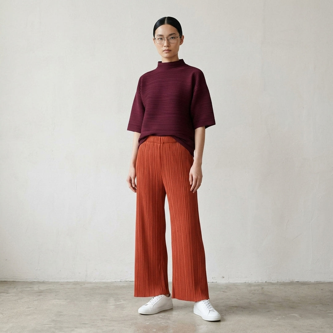 Pleats Please Issey Miyake Monthly Colors September wide-leg pants in black, featuring fine vertical micro-pleating and an elasticated waistband, displayed flat against a white background - lifestyle