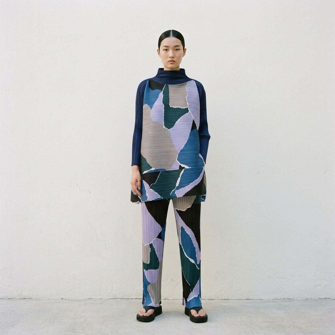 Pleats Please Issey Miyake SURPRISE! Pants in abstract multicolour geometric print featuring fuchsia, burgundy, coral, peach, and sage on permanent-pleat fabric with a straight-leg silhouette - lifestyle