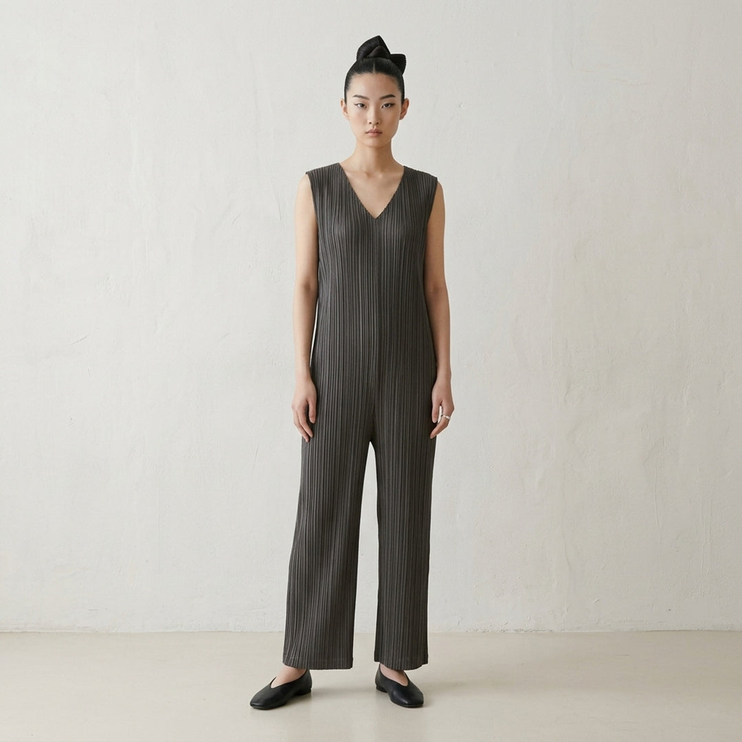 Pleats Please Issey Miyake Thicker Bottoms 2 Jumpsuit in charcoal, featuring a sleeveless V-neck with tonal lace trim, permanent-pleat fabric, and a relaxed wide-leg silhouette - lifestyle