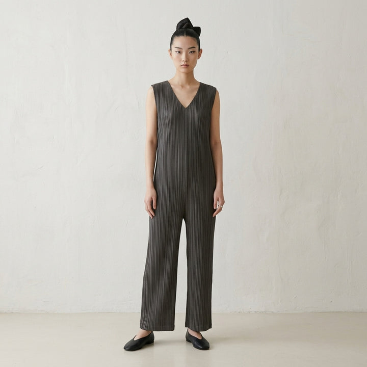 Pleats Please Issey Miyake Thicker Bottoms 2 Jumpsuit in charcoal, featuring a sleeveless V-neck with tonal lace trim, permanent-pleat fabric, and a relaxed wide-leg silhouette - lifestyle