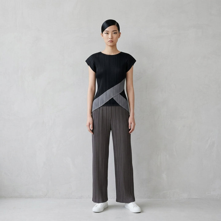 Pleats Please Issey Miyake Thicker Bottoms 2 wide-leg pleated trousers in charcoal grey with vertical plissé texture and elasticated waistband, front view - lifestyle