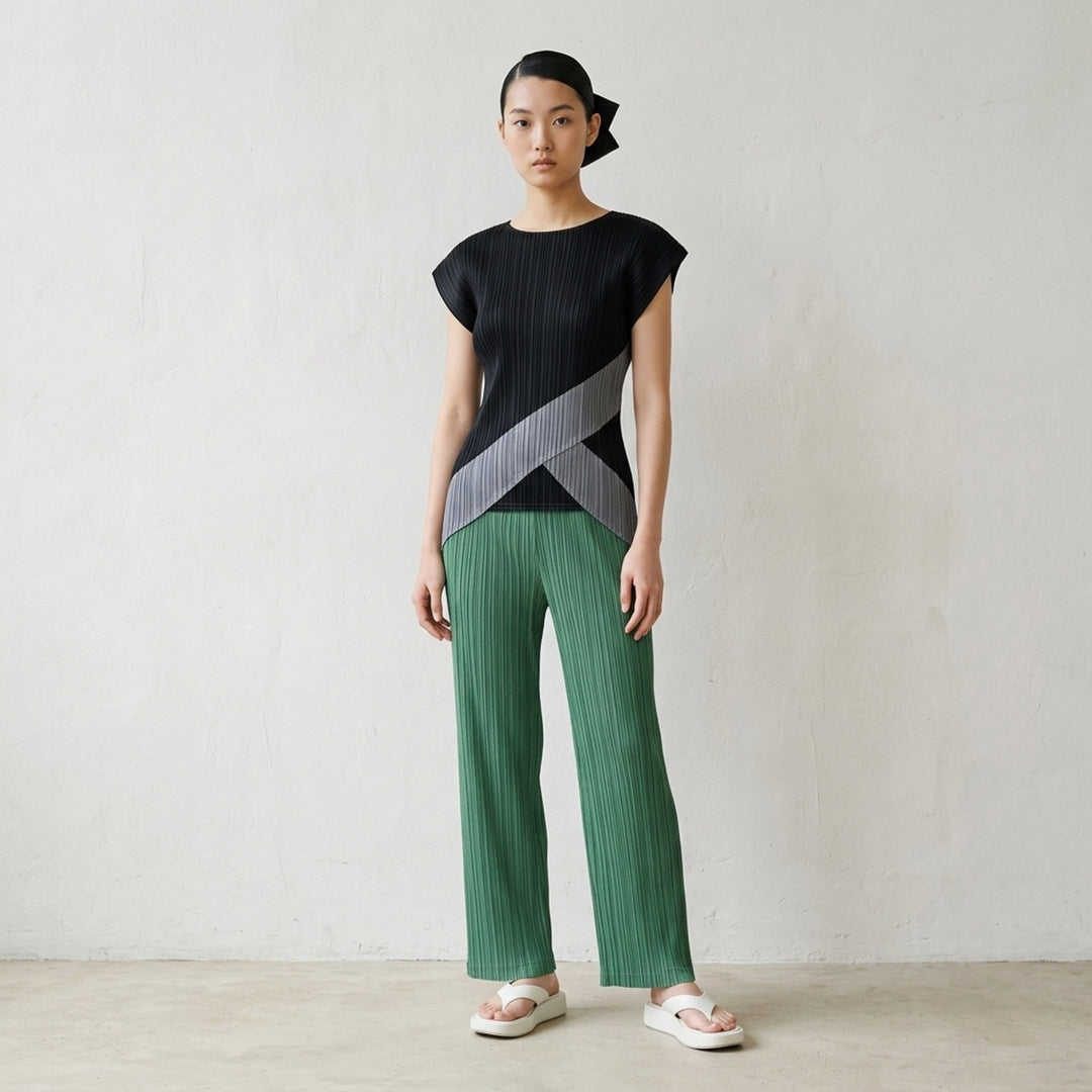 Pleats Please Issey Miyake Thicker Bottoms 2 wide-leg pleated trousers in charcoal grey with vertical plissé texture and elasticated waistband, front view - lifestyle