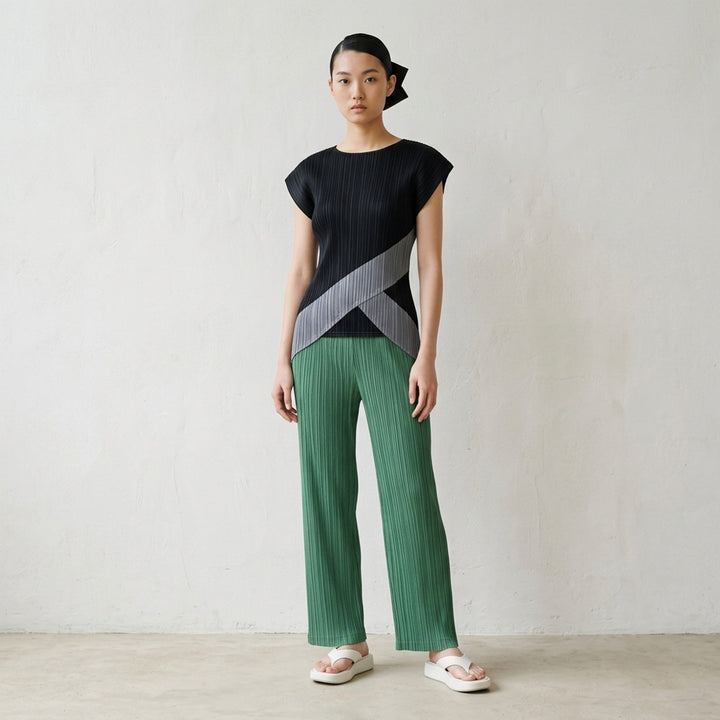 Pleats Please Issey Miyake Thicker Bottoms 2 wide-leg pleated trousers in charcoal grey with vertical plissé texture and elasticated waistband, front view - lifestyle