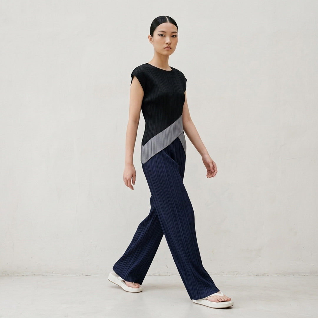 Pleats Please Issey Miyake Thicker Bottoms 2 wide-leg pleated trousers in charcoal grey with vertical plissé texture and elasticated waistband, front view - lifestyle
