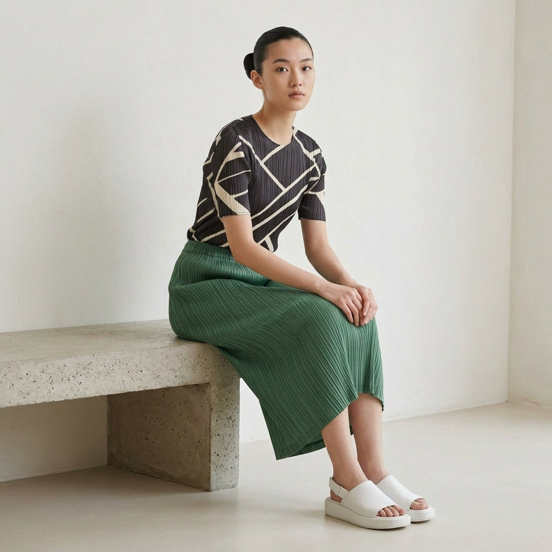 Pleats Please Issey Miyake Thicker Bottoms 2 pleated midi skirt in dark charcoal grey with vertical permanent pleating and elasticated waistband - lifestyle