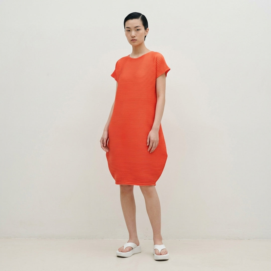 Pleats Please Issey Miyake Zig Zag Knit Dress in black, featuring horizontal ribbed pleating, cap sleeves, and a sculpted tulip-shaped skirt, shown from the back on a white background - lifestyle