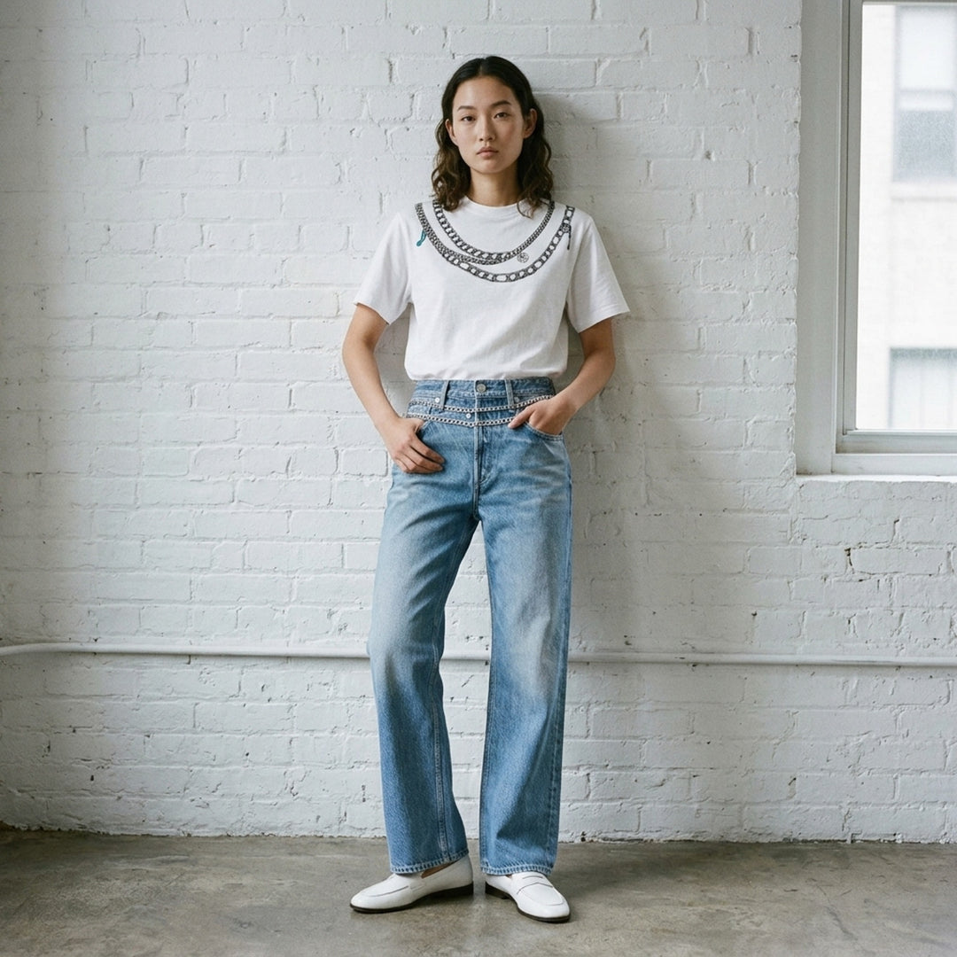 rag & bone Miramar Charm Wide Leg Jeans in mid-blue faded wash with silver chain trim along the waistband, five-pocket detailing, and a relaxed straight-leg silhouette - lifestyle