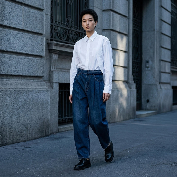 sacai belted wide-leg barrel jeans in washed black denim with deep front pleats, contrast stitching, and tapered hem, photographed flat on white background - lifestyle