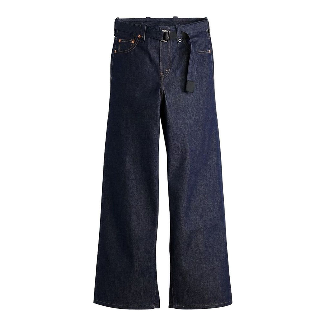 sacai wide-leg washed blue jeans with layered waistband and black belt with metal buckle, shown from the front - packshot