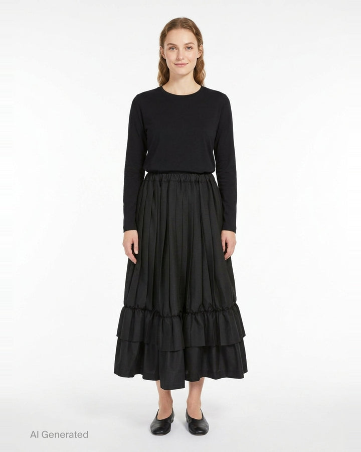 Tao black layered pleated midi skirt with elasticated waist, vertical pleats, gathered mid-section, and double-tiered ruffled hem, displayed on white background - front
