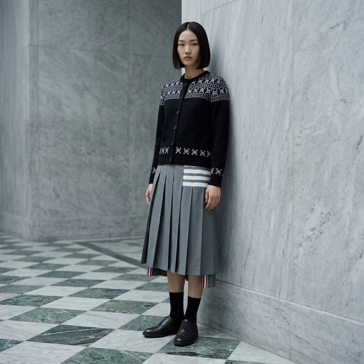 Thom Browne black crewneck cardigan with white and grey snowflake Fair Isle yoke, hem and cuffs, shown front-facing with button-through closure - lifestyle