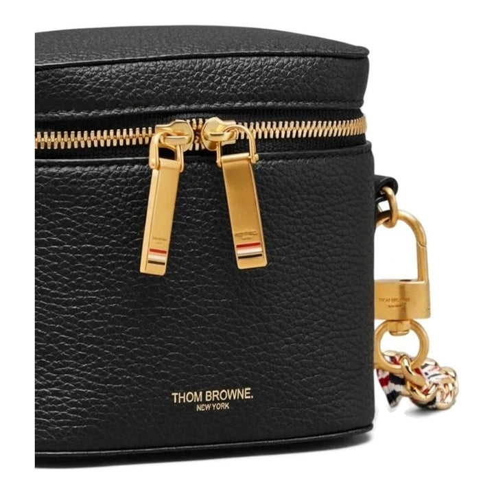 Thom Browne burgundy pebbled leather box pouch with double gold-tone zip closure and long crossbody chain strap featuring red, white, and blue woven ribbon interlaced with gold links - packshot