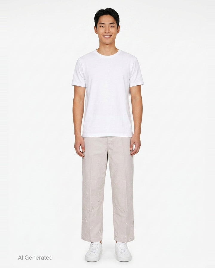 visvim Survey Damaged Pants in light stone, wide-leg silhouette with paint-splatter distressing on lower leg panels, front view on white background - front