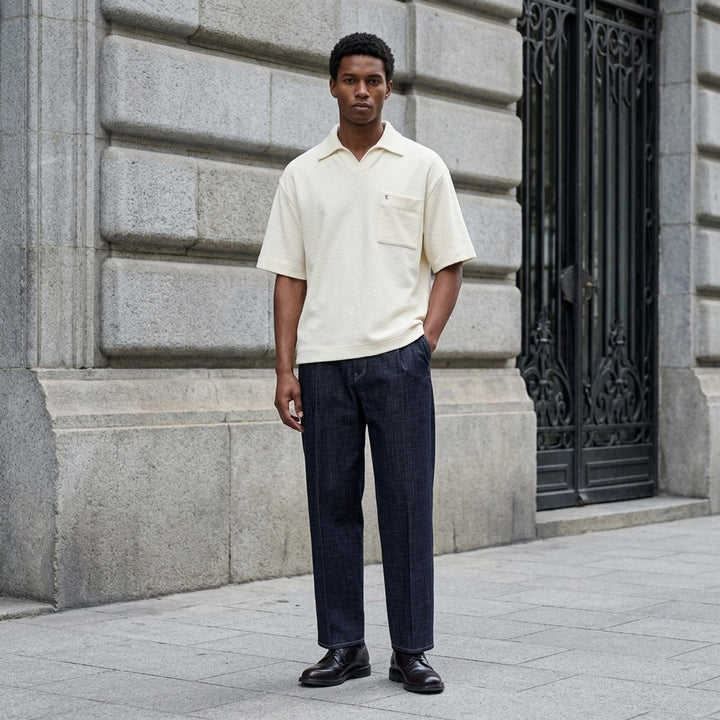 Wooyoungmi Oversized Textured Polo in black, featuring an open-placket collar, boxy short-sleeve silhouette, chest patch pocket with tonal WM monogram badge, and side hem vents - lifestyle