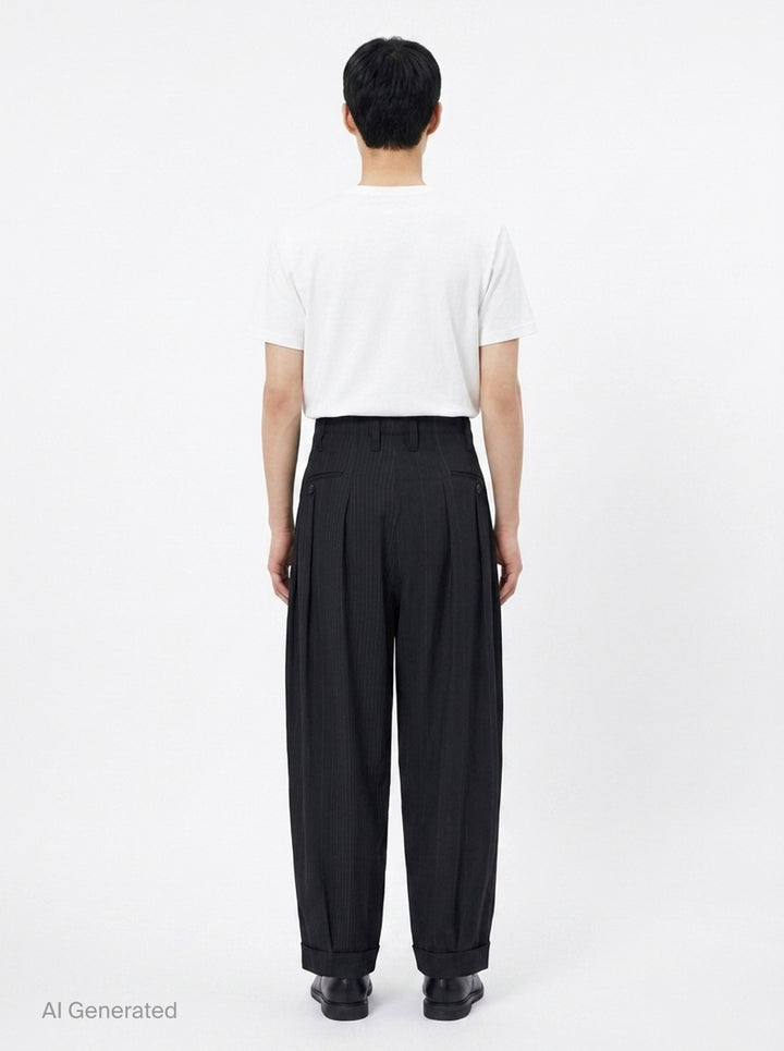 Yohji Yamamoto Hem Tab Wide Tuck Pants in black pinstripe, featuring a high-rise waistband, deep forward pleats, voluminous wide-leg silhouette, and buttoned cuff tab detailing at the hem - back